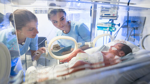Nurses looking a baby in intensive care